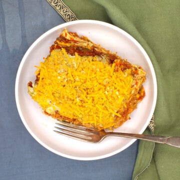 Vegan crockpot lasagna in white bowl with fork.