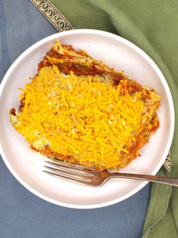 Vegan crockpot lasagna in white bowl with fork.