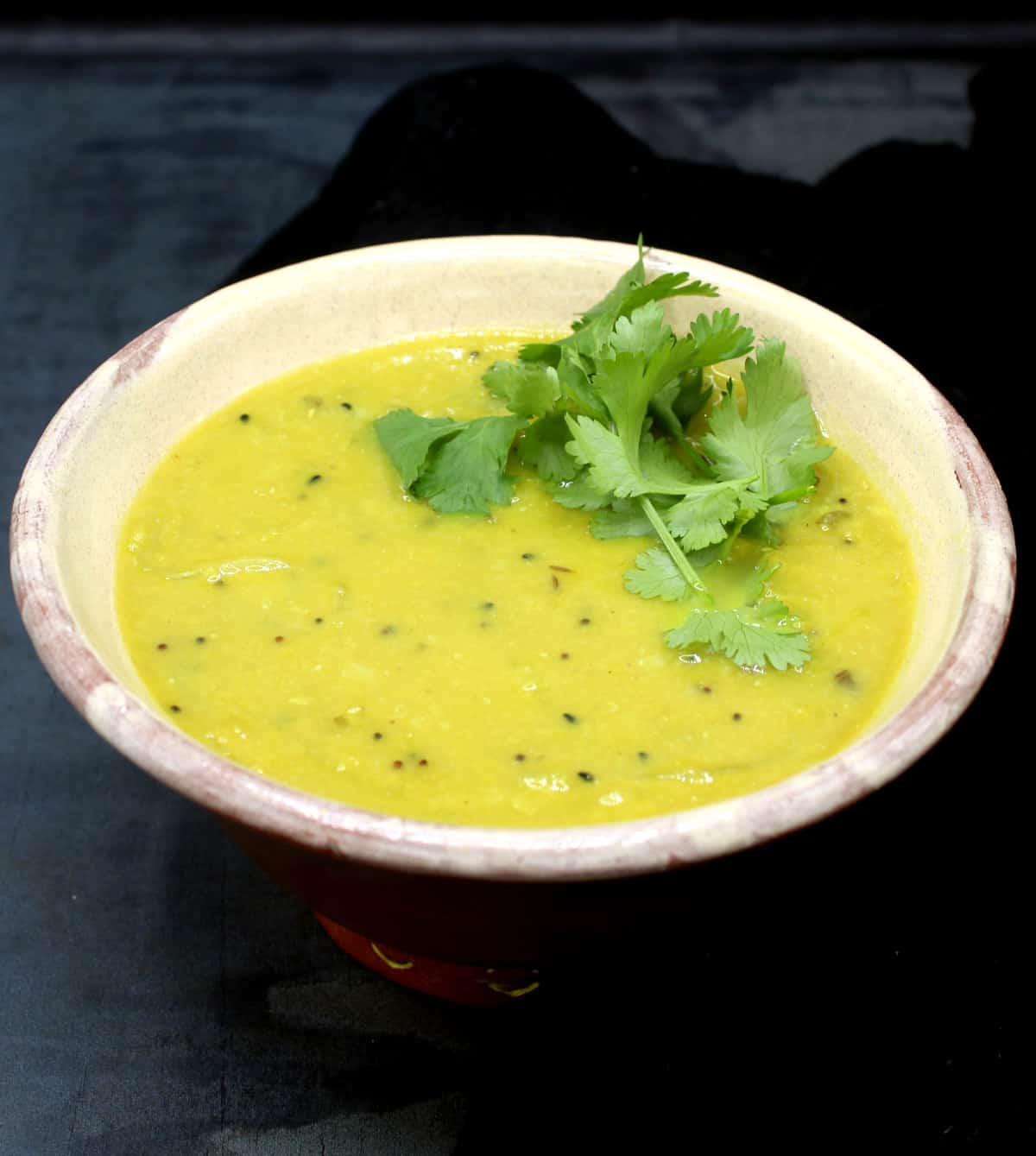 Bengali dal in earthen pot garnished with coriander leaves.