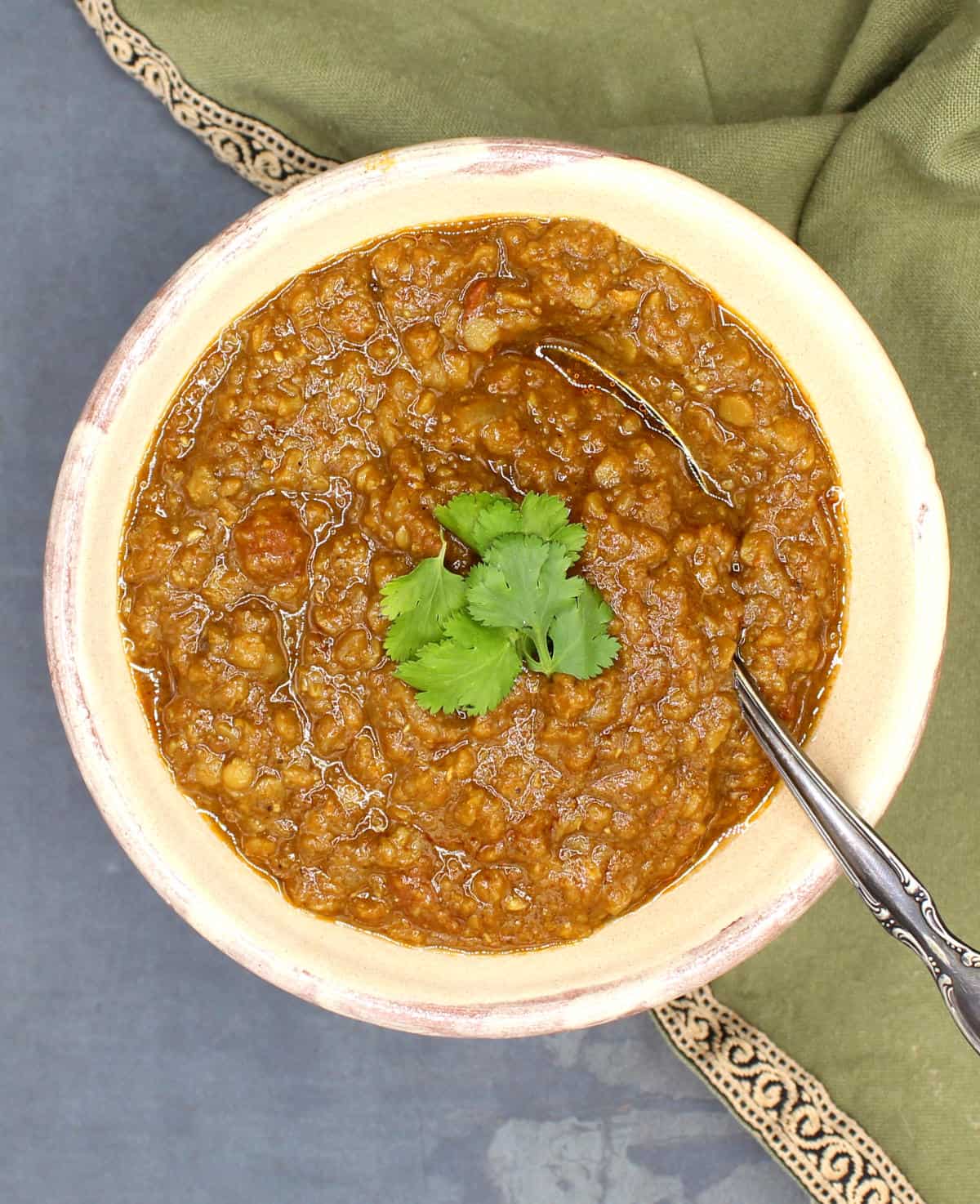 Ethiopian lentil stew in bowl with cilantro and a spoon.