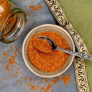 Ras el hanout spice blend in bowl with spoon.
