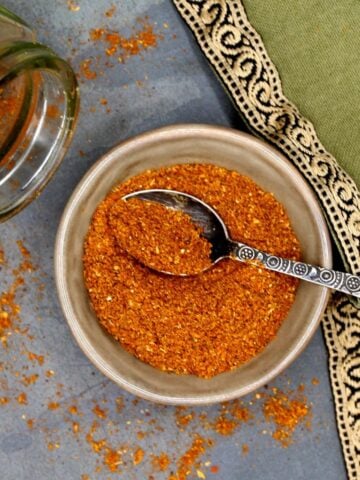 Ras el hanout spice blend in bowl with spoon.