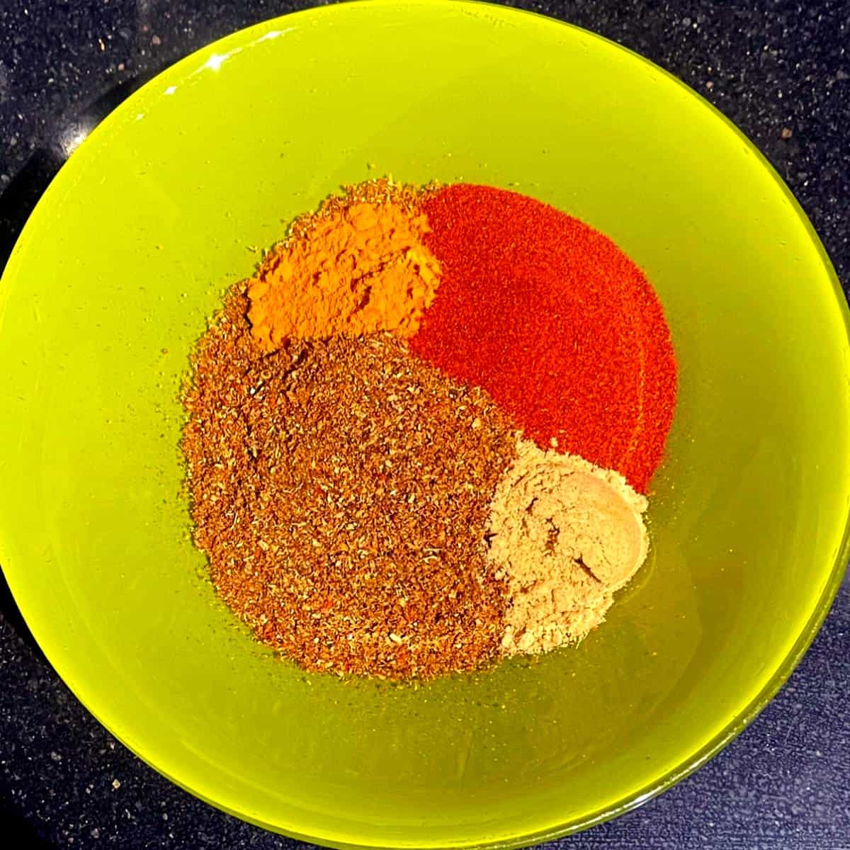 Kryddor för marockansk ras el hanout blandas i skål.