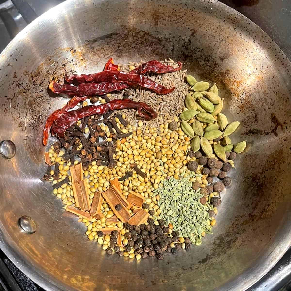 Hela kryddor till ras el hanout i stekpanna.