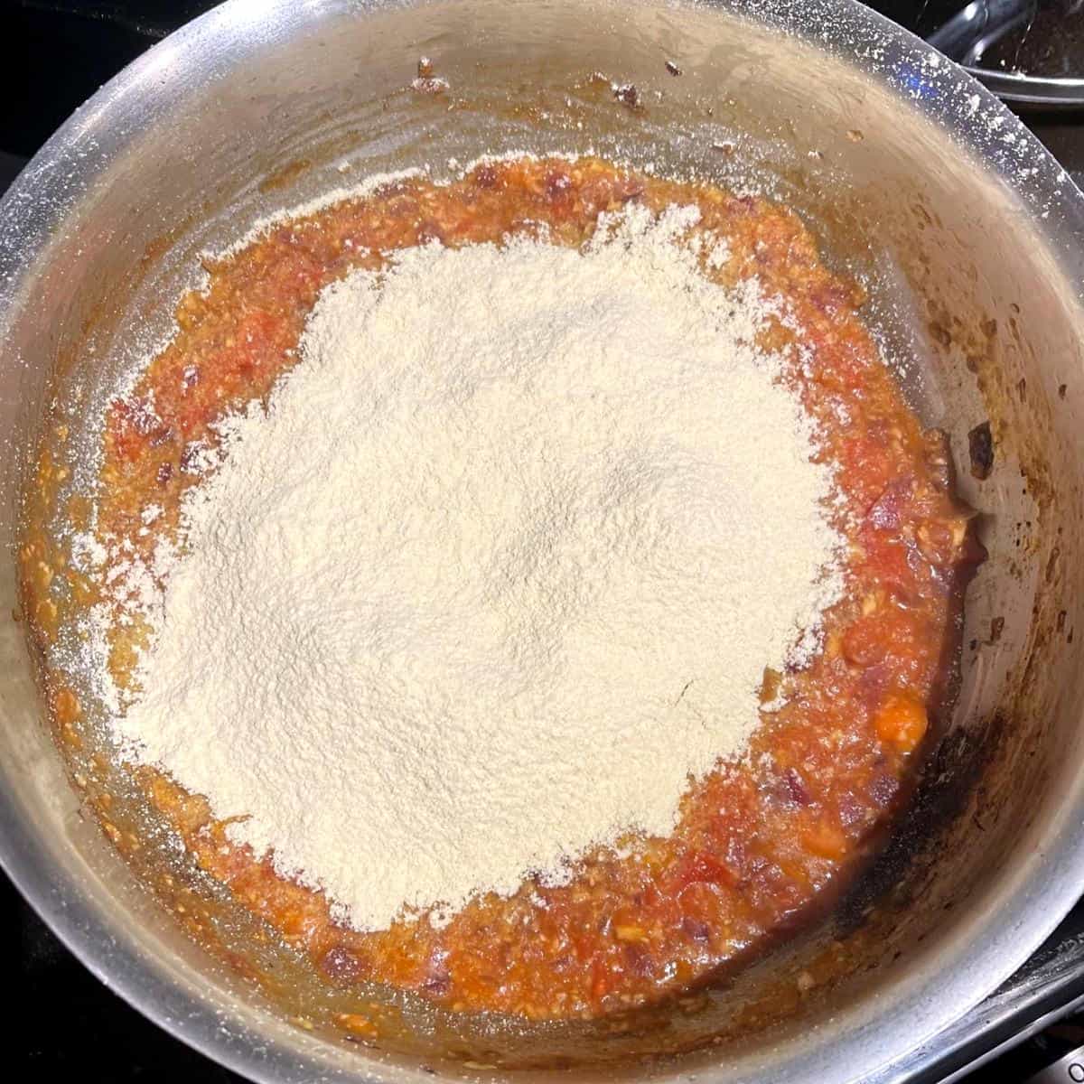 Chickpea flour added to tomatoes and onions.