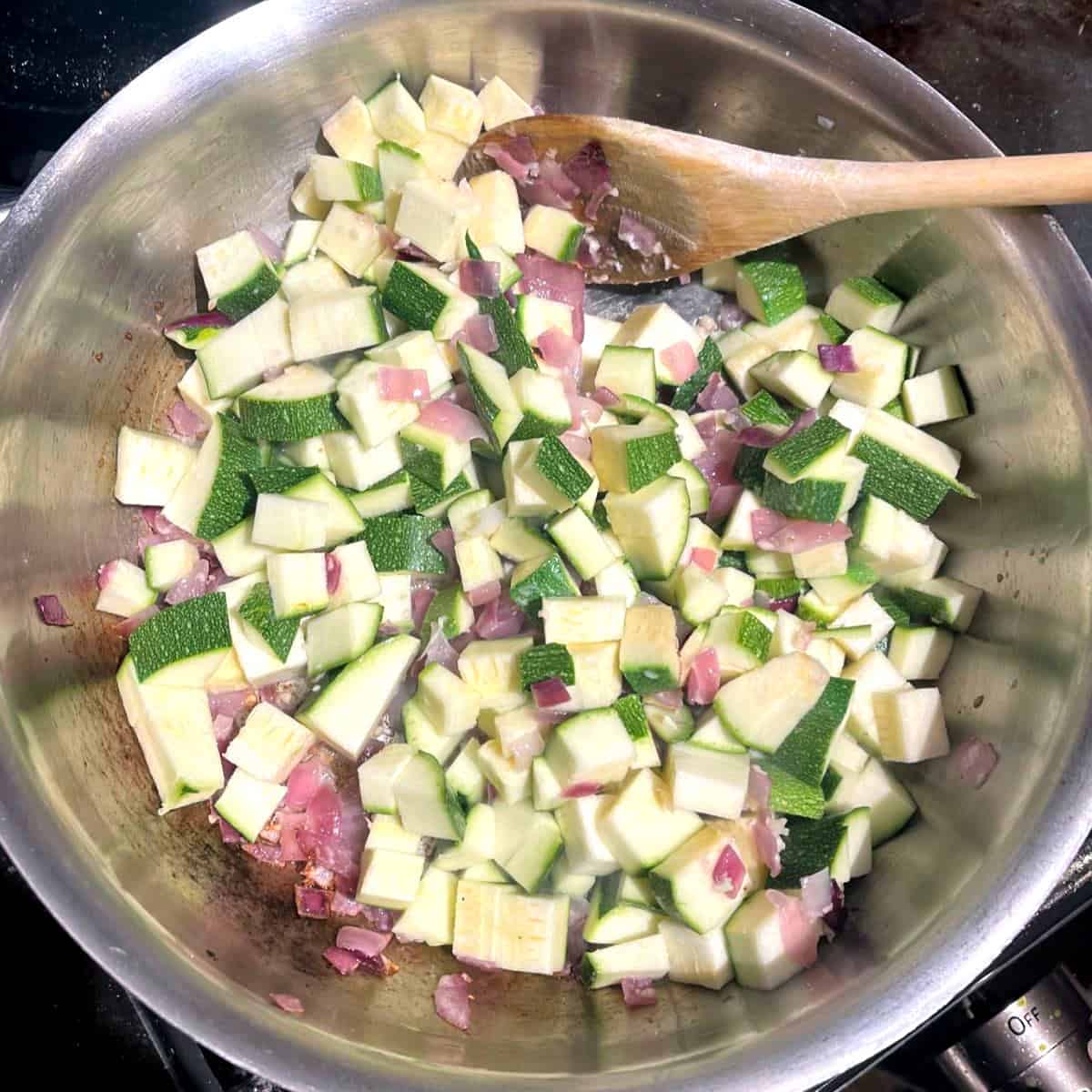 Zucchini added to onions and garlic in saute pan.