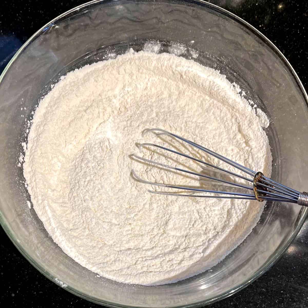 Dry ingredients for vanilla cupcakes mixed in bowl.
