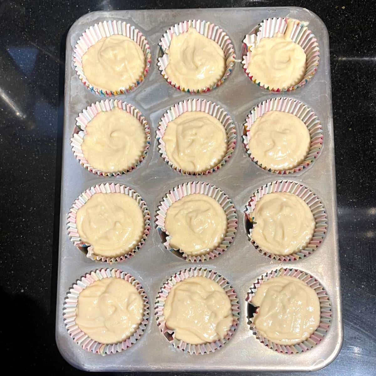 Vegan vanilla cupcake batter divided in cupcake pan.
