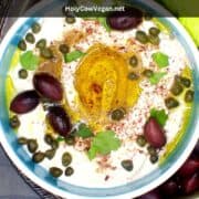 The bowl says vegan labneh with olives, olive oil, parsley and za'atar "Vegan labneh, tangy and delicious."