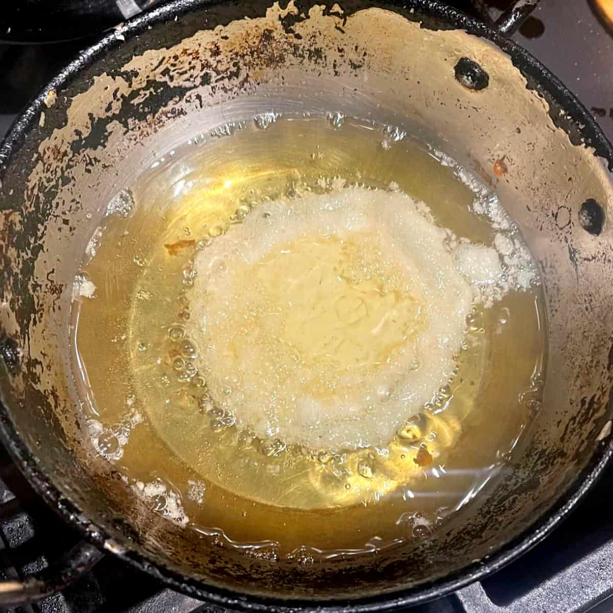 Vegan malpua frying in oil.
