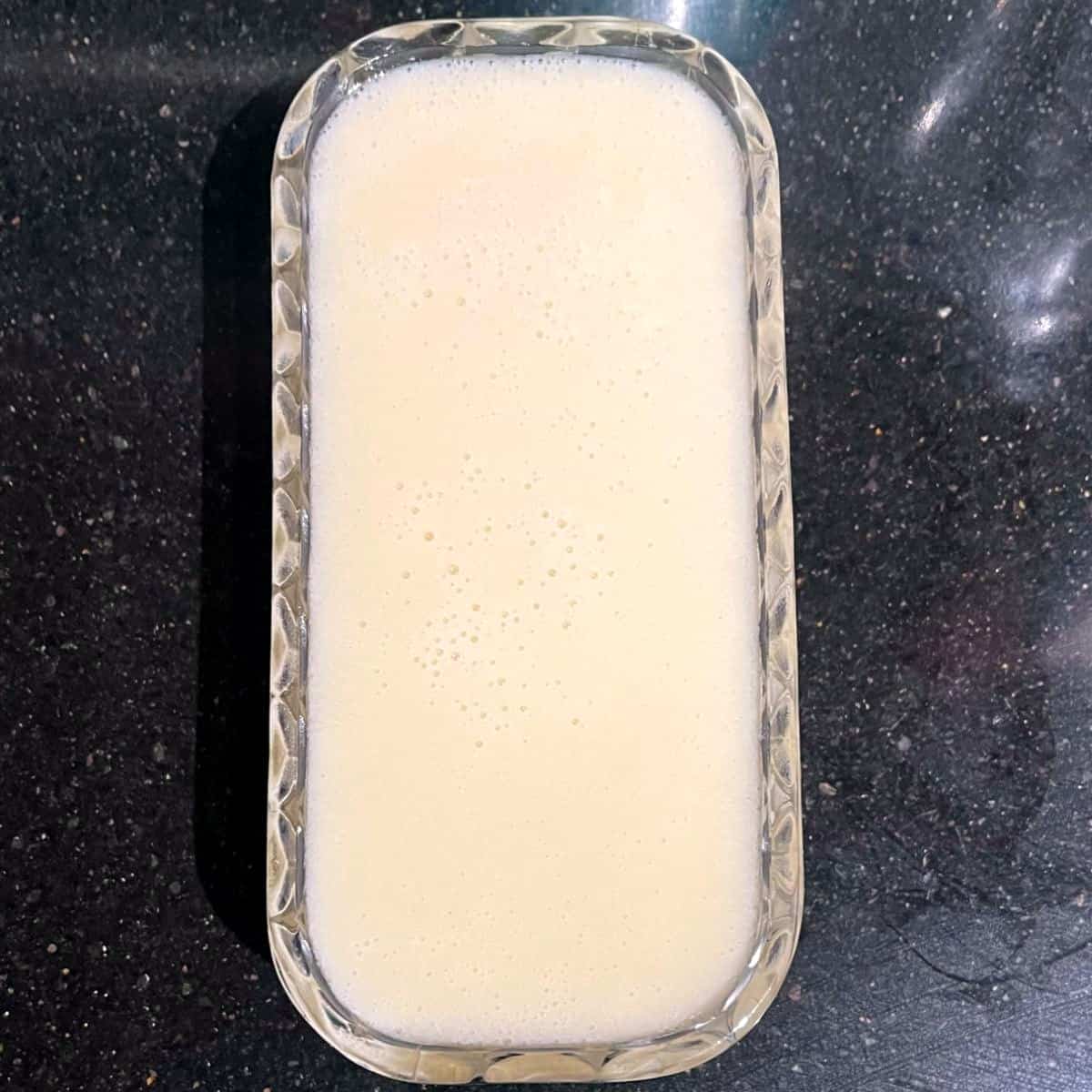 Vegan spreadable butter pours into butter dish.