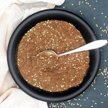 Za'atar in black plate with silver spoon.