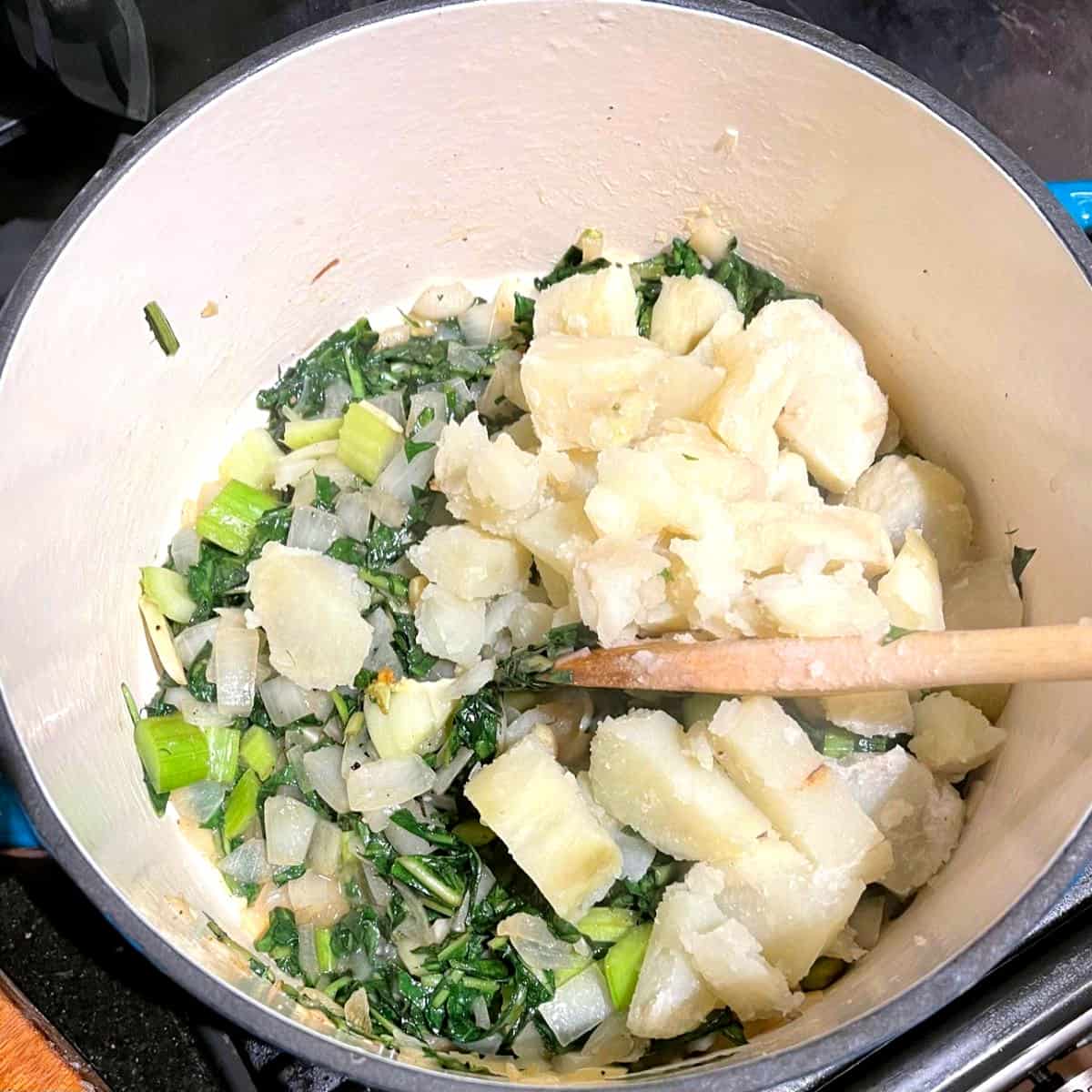 Potatoes added to pot with dandelion greens for soup.