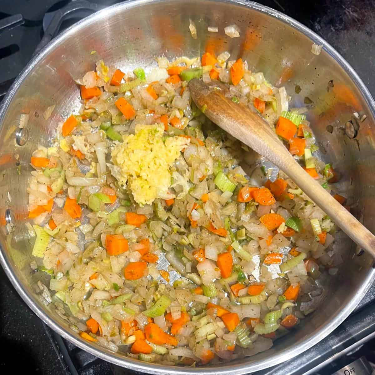 Garlic added to veggies in skillet.