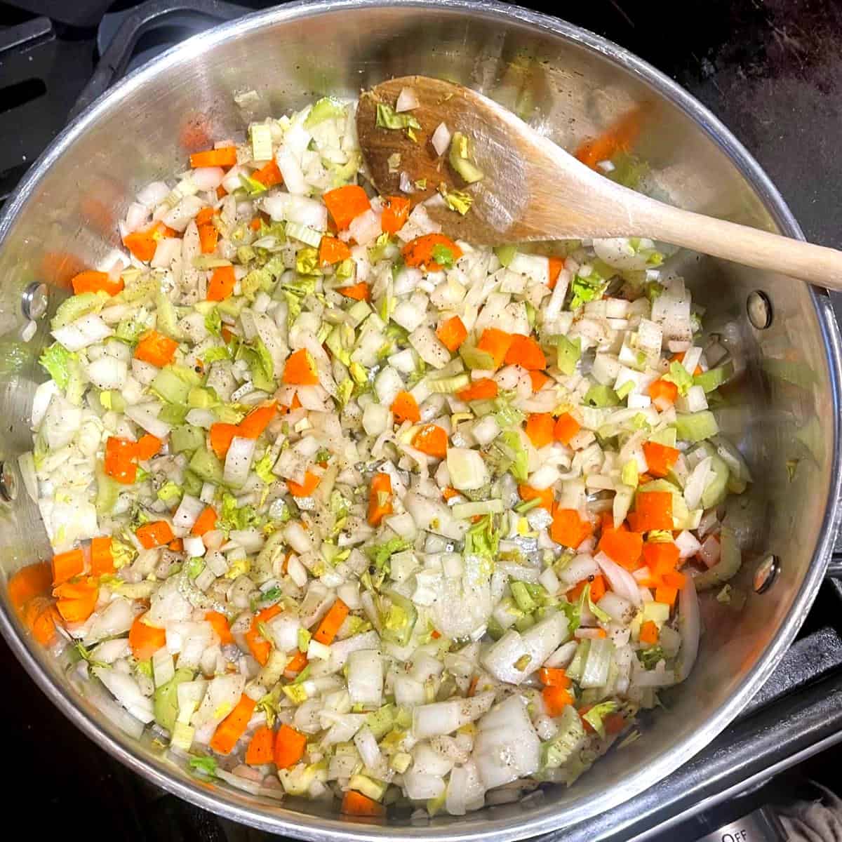 Carrots, celery, onions cooking in skillet.