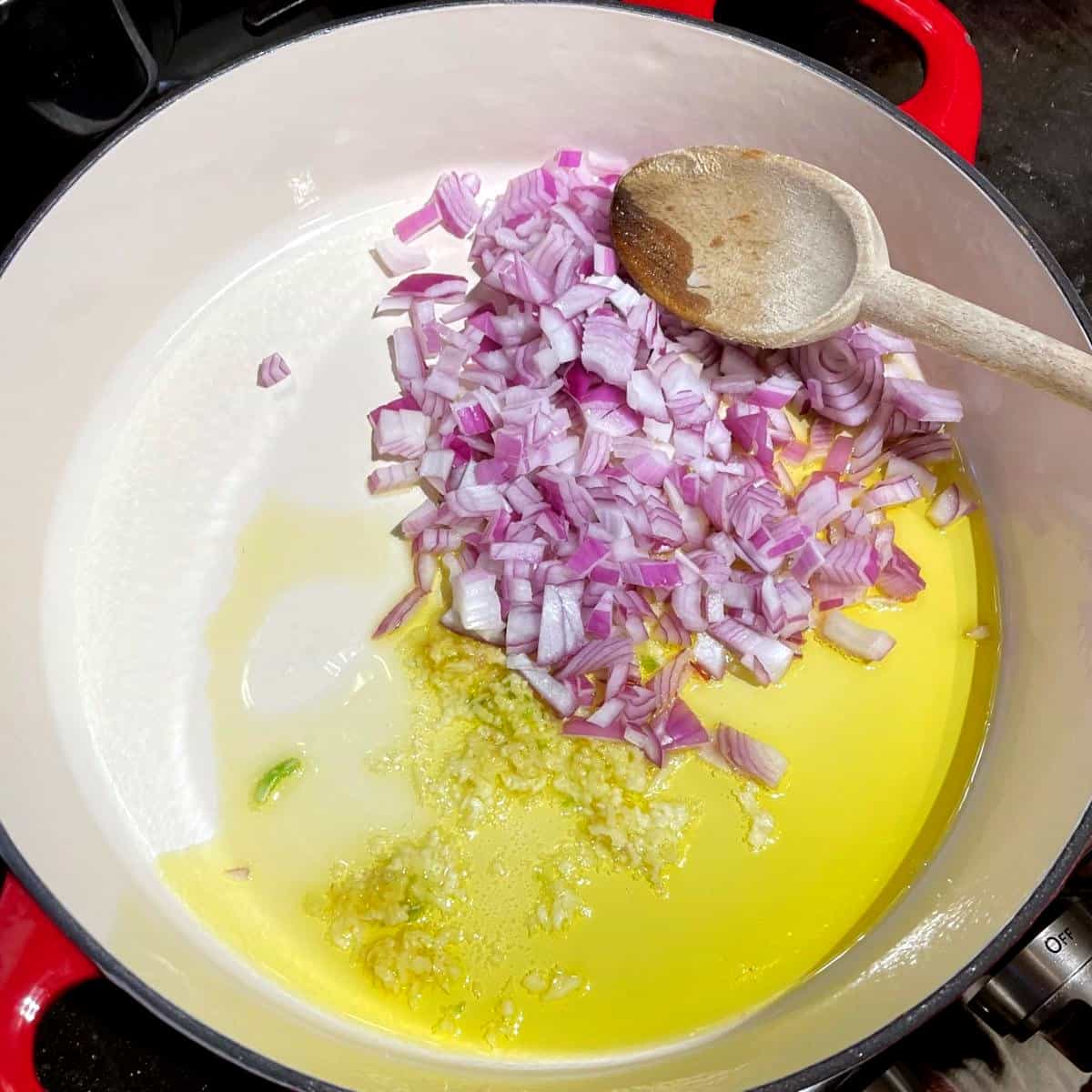 Onions and garlic added to olive oil in skillet.
