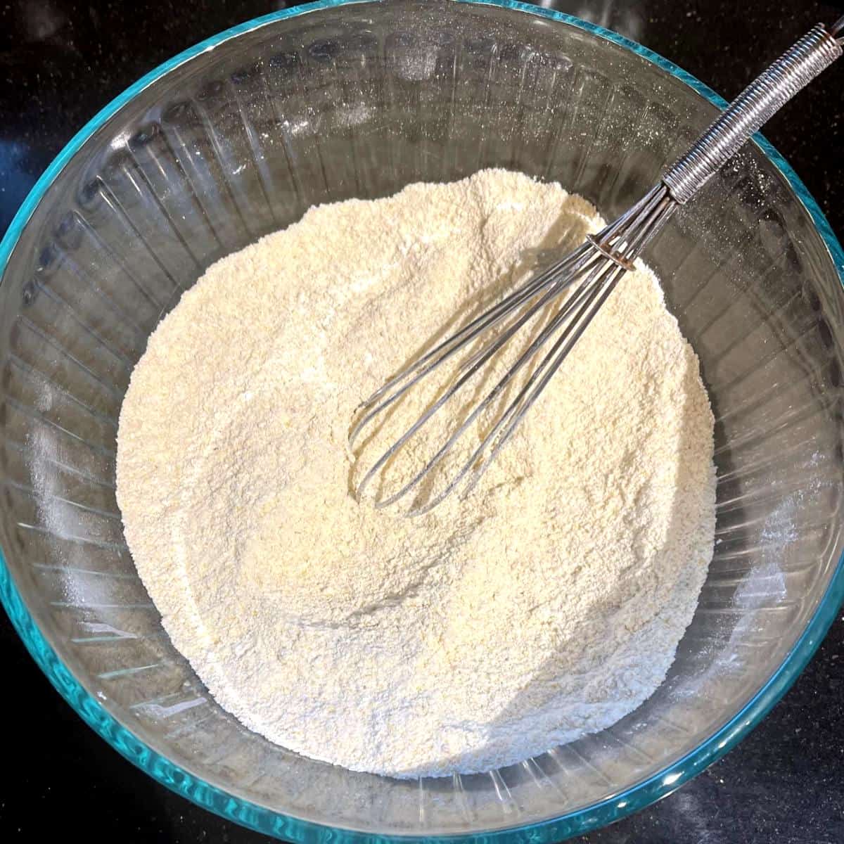 Flours whisked together in bowl with whisk.