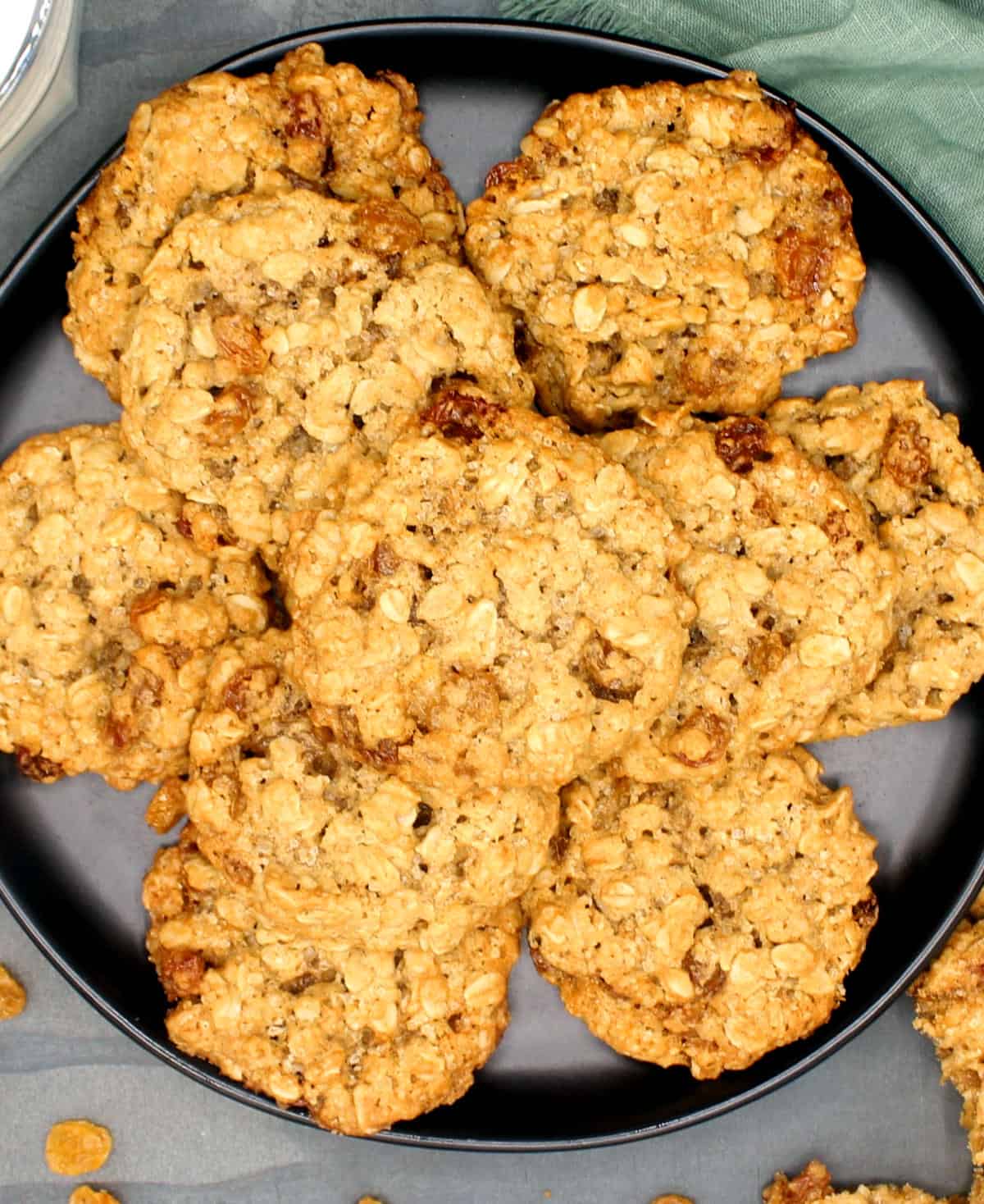 Fresh-baked vegan oatmeal cookies on black plate.