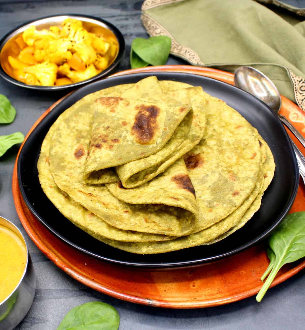 High-protein roti on black plate with dal and sabzi on side.
