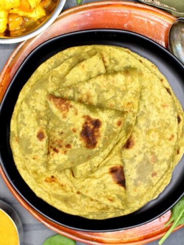 High-protein roti on black plate with dal and sabzi on side.