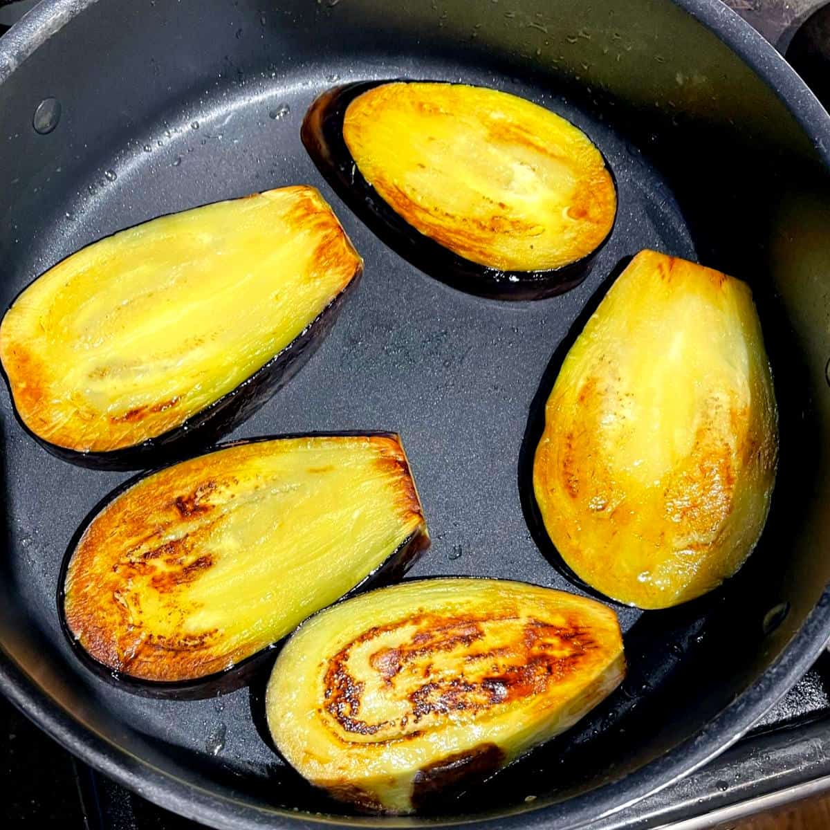Eggplant slices frying in saute pan for khoresh bademjan.