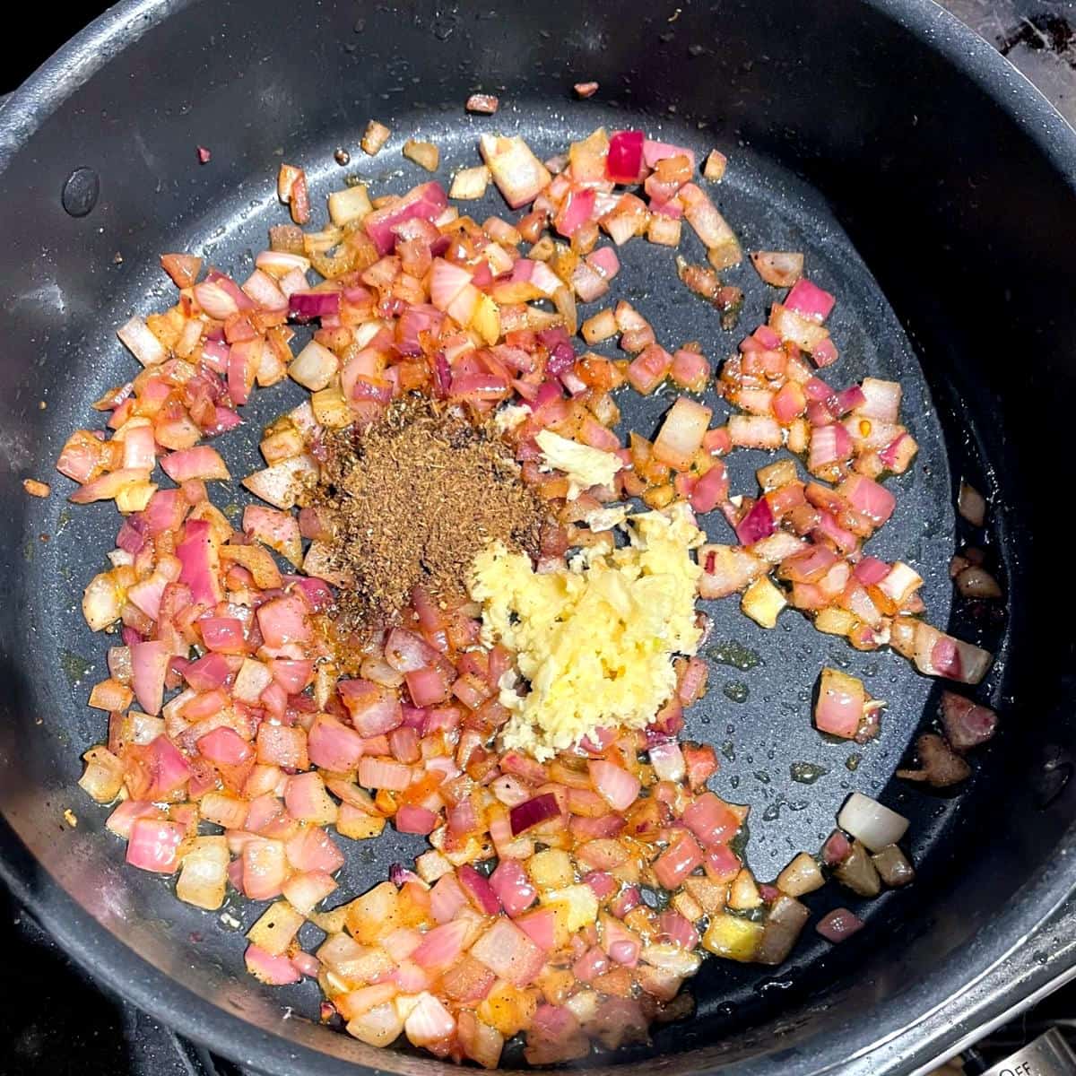 Spices and garlic added to onions for khoresh bademjoon.