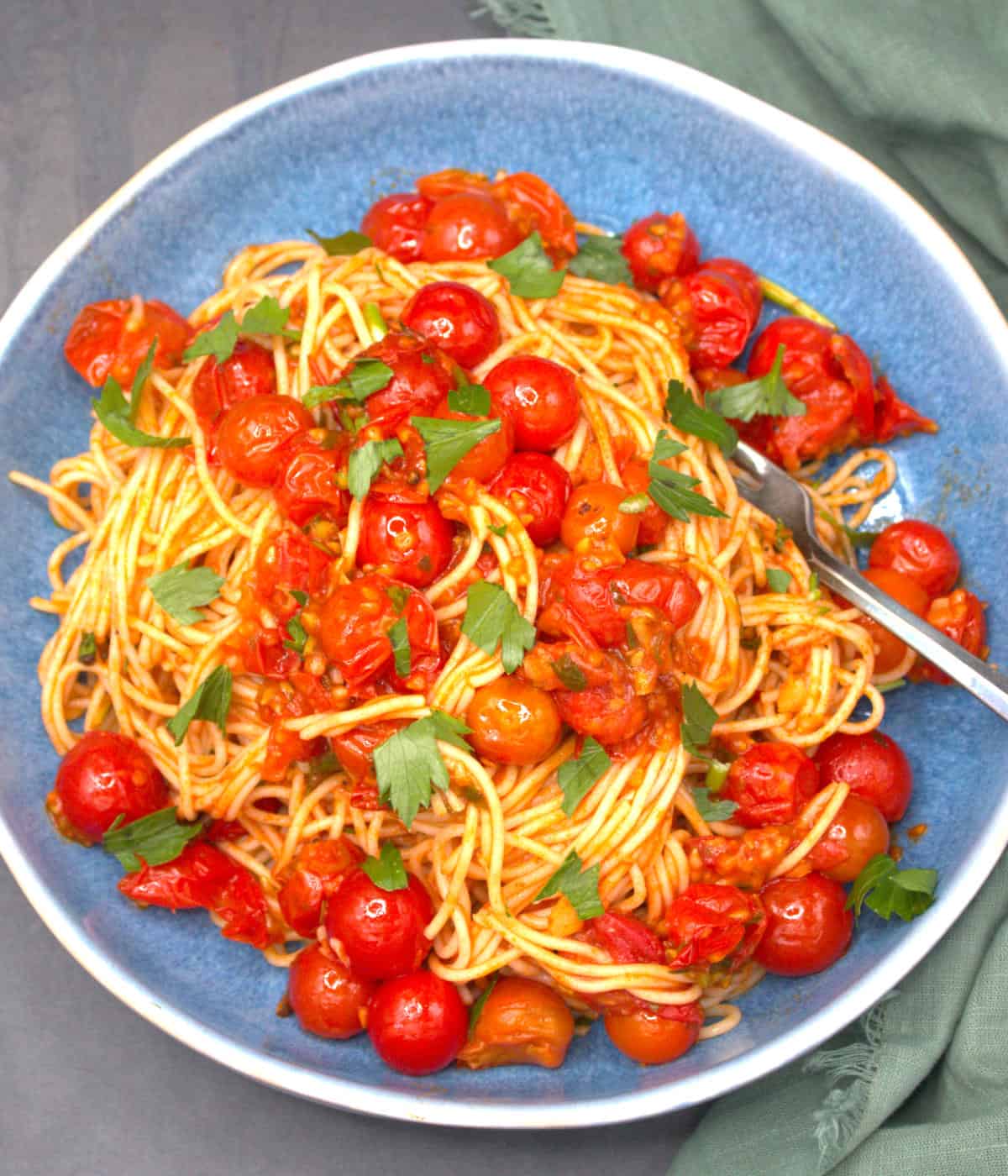 Cherry tomato pasta with angel hair spaghetti in bowl with spoon.