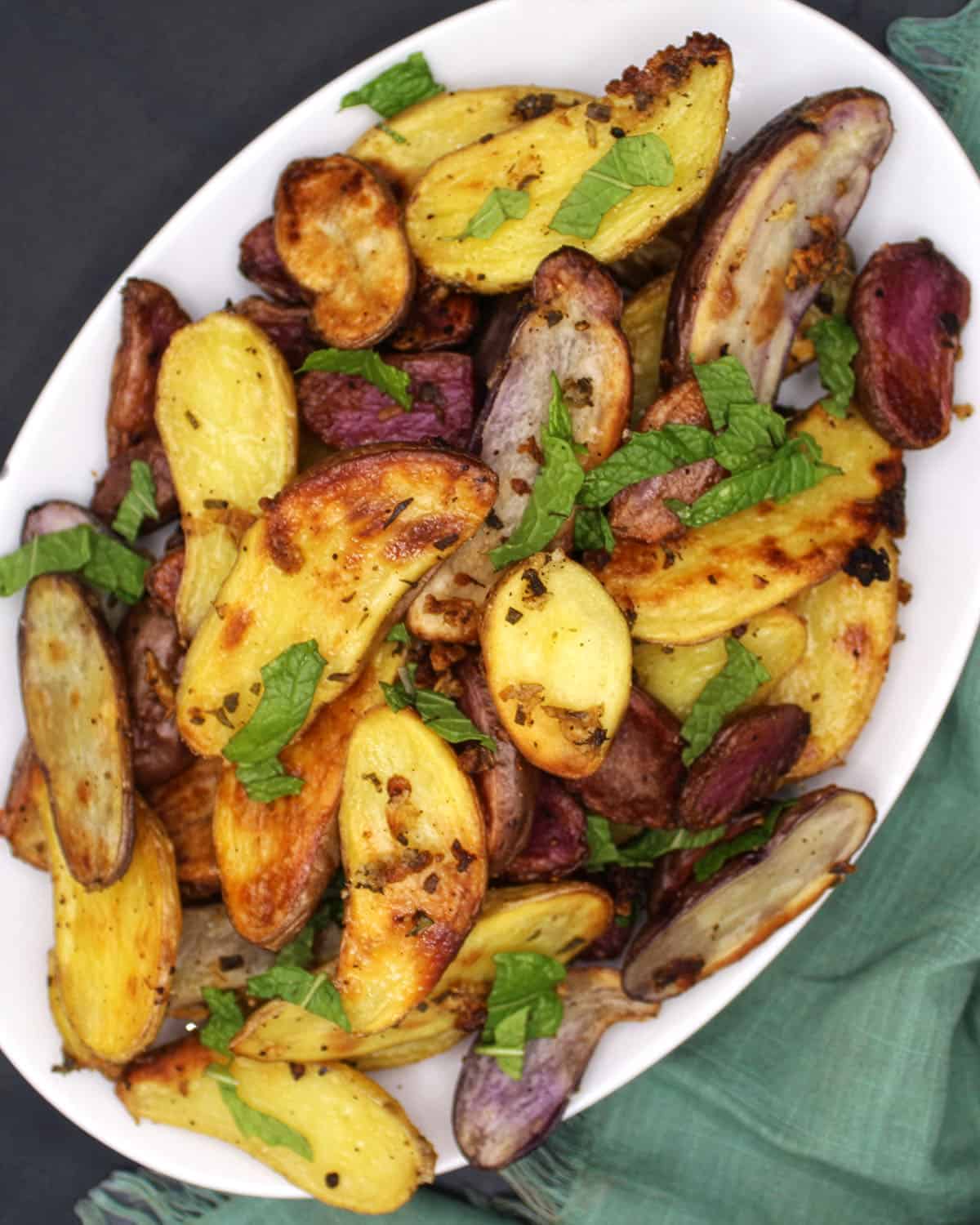 Roasted fingerling potatoes on white platter.