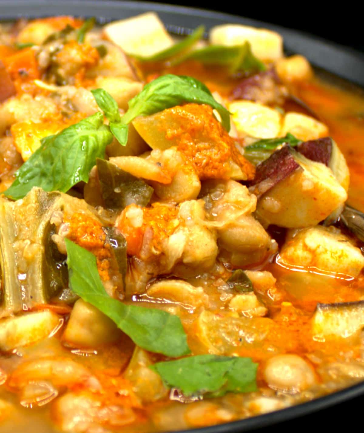 Vegetable stew with basil in bowl.