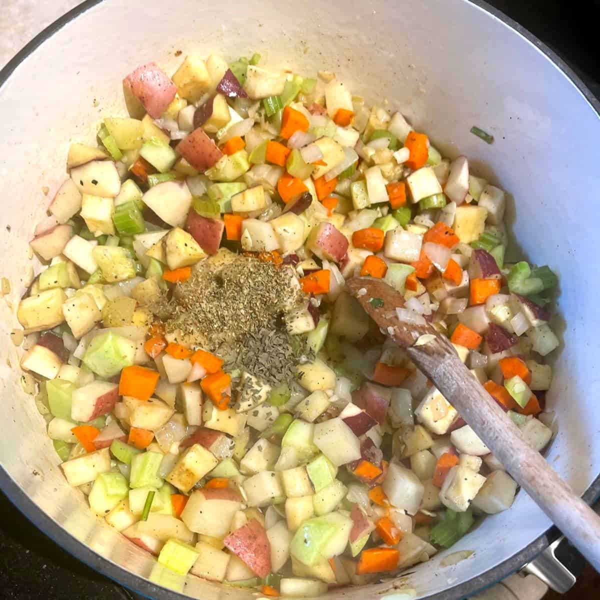 Herbs added to veggies for vegetable stew in dutch oven.