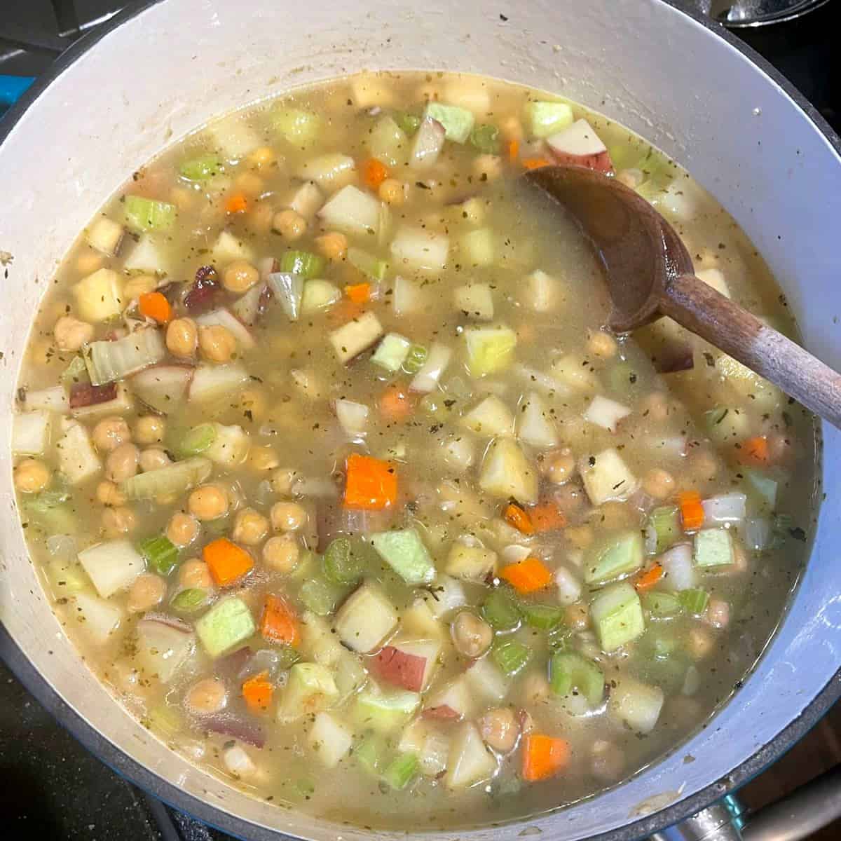 Vegetable stock or water added to dutch oven with vegetable stew.