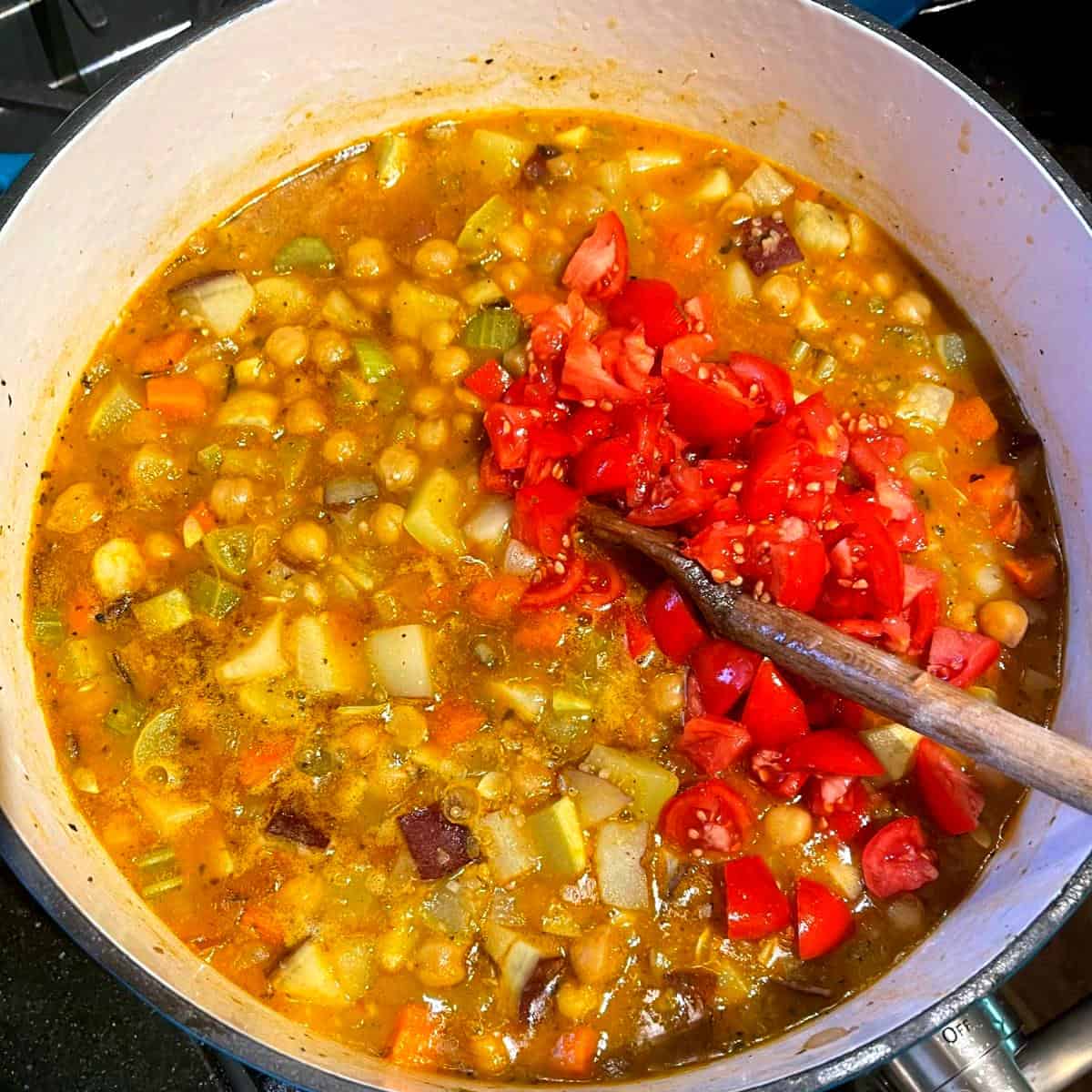 Chopped tomatoes added to stew.