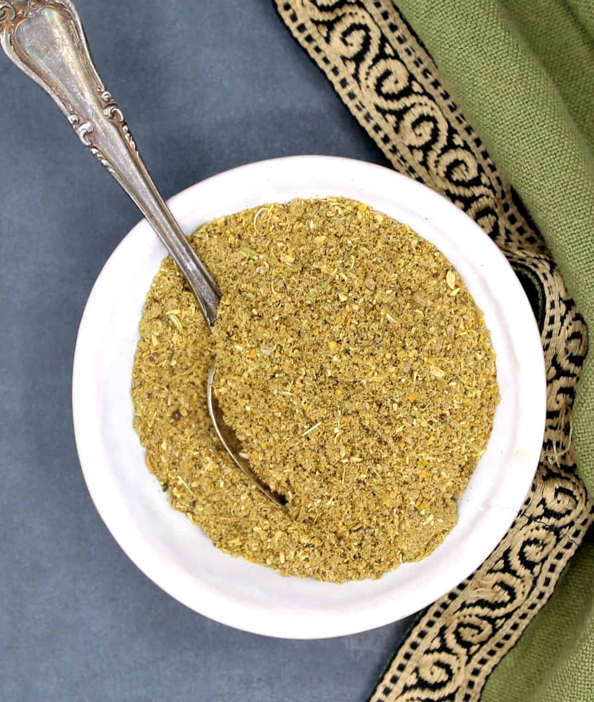Amchar masala powder in bowl with spoon.