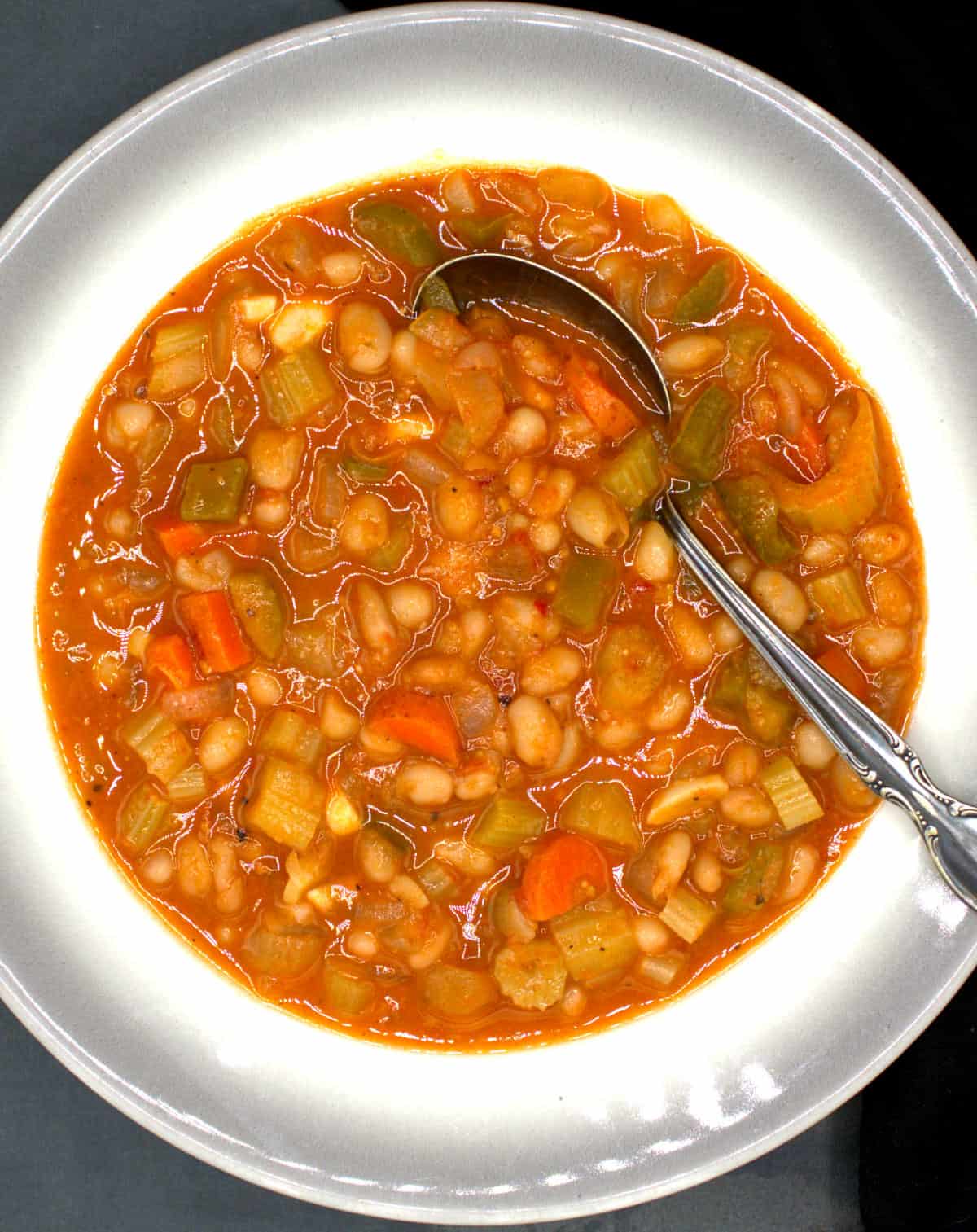 Fasolada, a traditional Greek bean soup, in bowl with spoon.