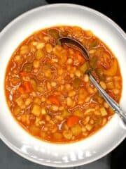Fasolada, Greek white bean soup, in bowl with spoon.