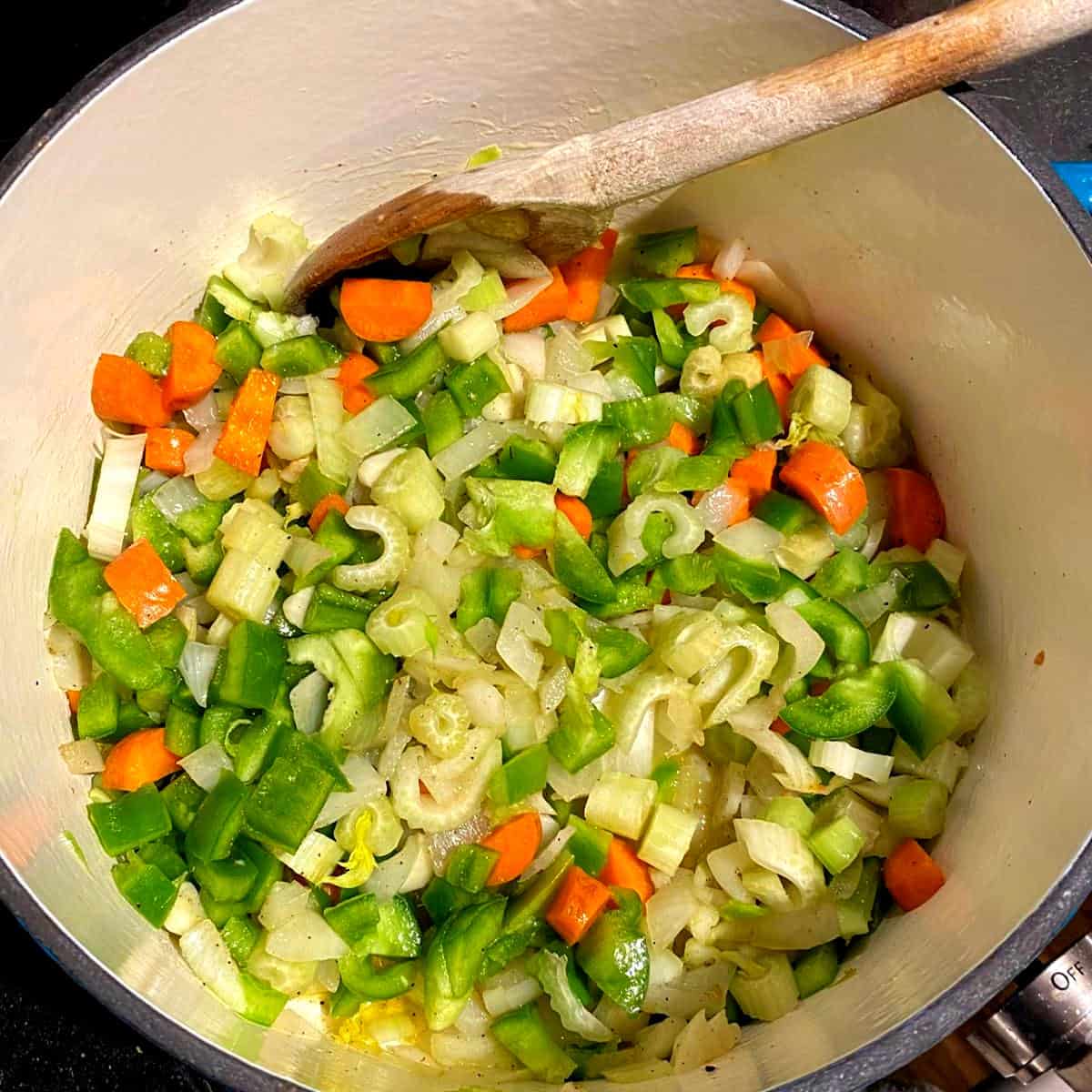 Carrots, celery, onions and garlic for fasolada sauteing in a Dutch oven.
