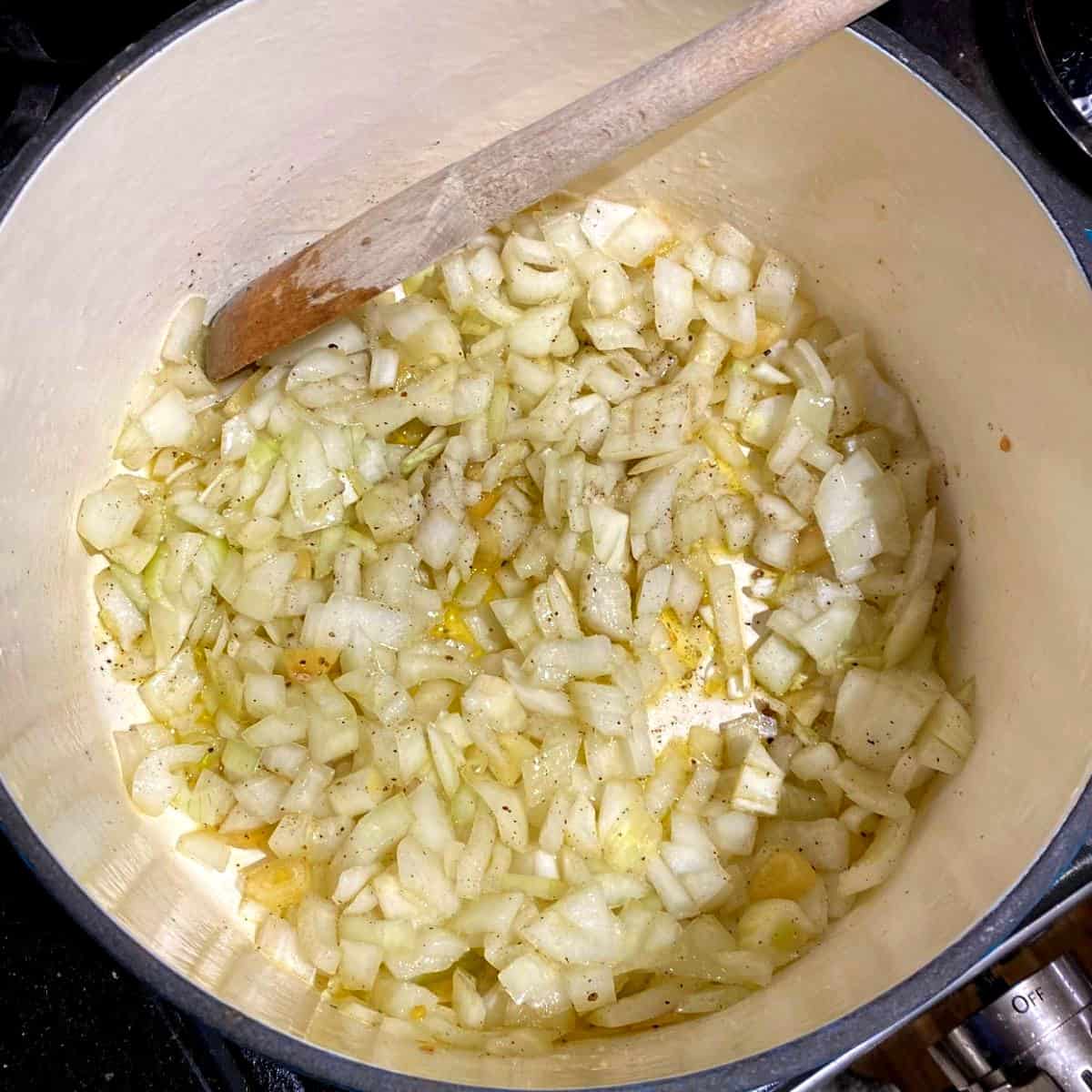Onions and garlic sauteing in Dutch oven for fasolada, a greek bean soup.
