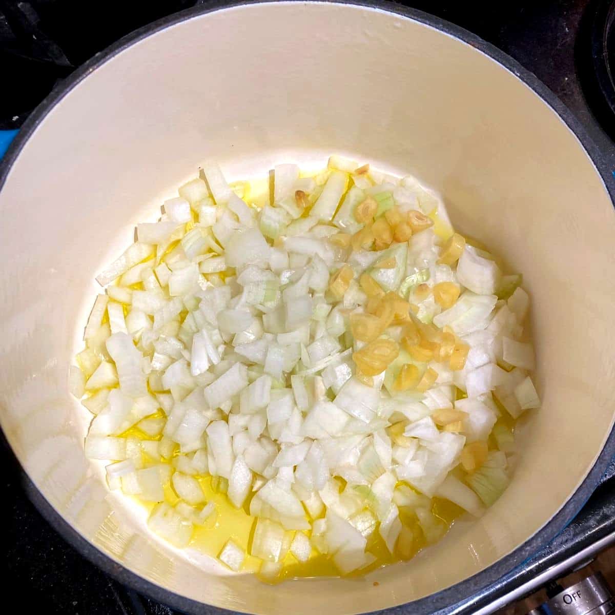 Onions and garlic in Dutch oven for fasolada.