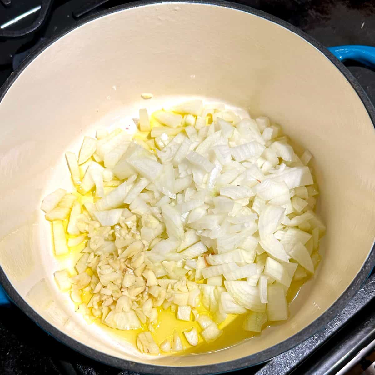 Onions and garlic sauteing in olive oil for vegan potato soup.
