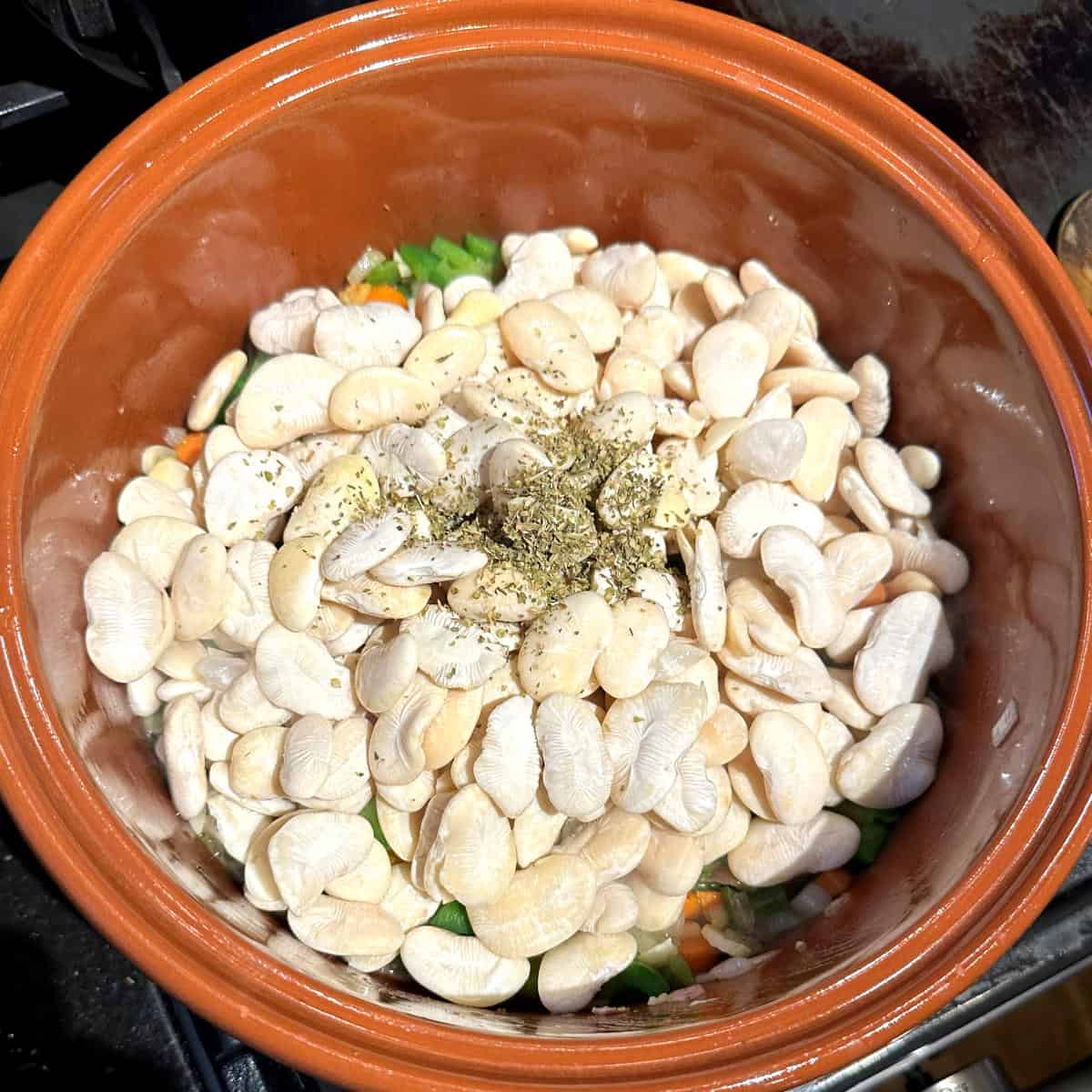 Lima beans and herbs added to pot for creamy butter beans recipe.