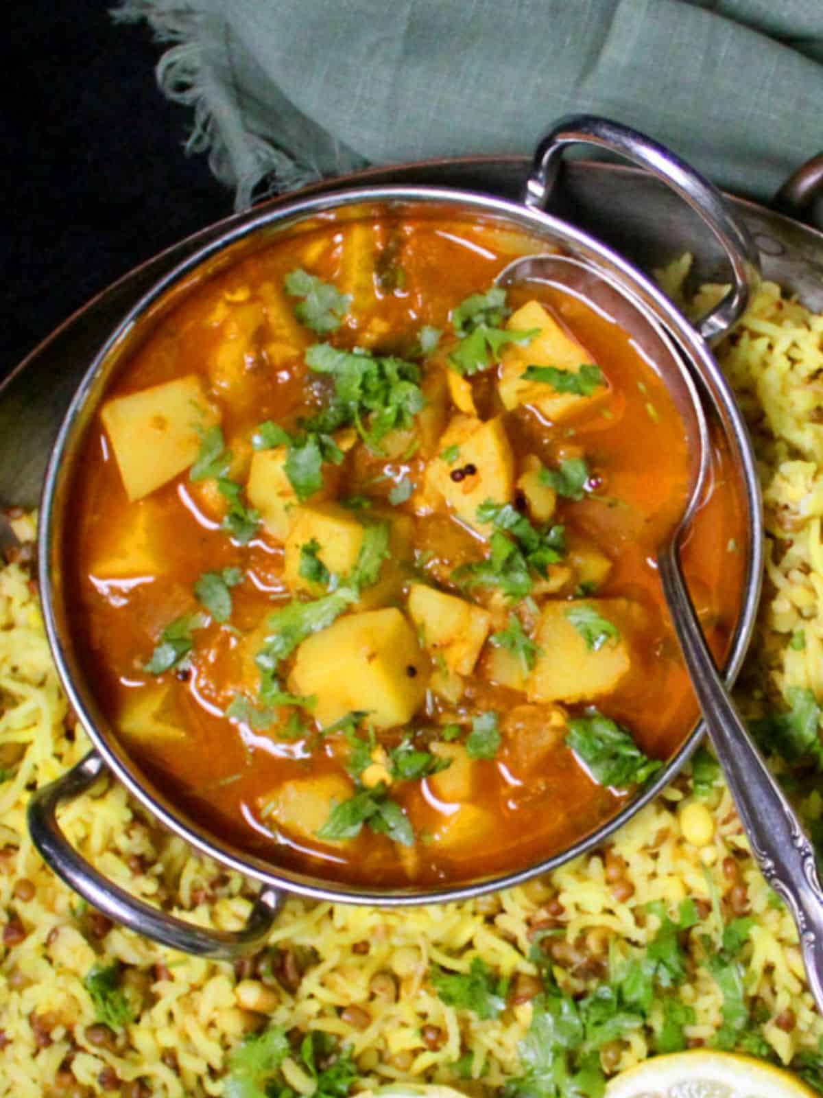 Potato curry in bowl on a bed of khichdi rice.