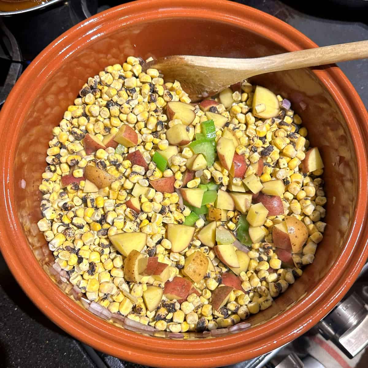 Fire roasted corn and potatoes added to pot with onions, celery and garlic.
