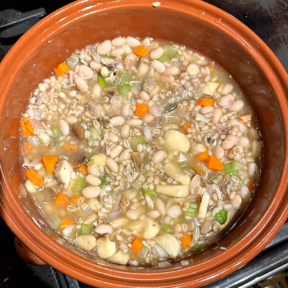 Cooked barley and beans added to pot with veggies.