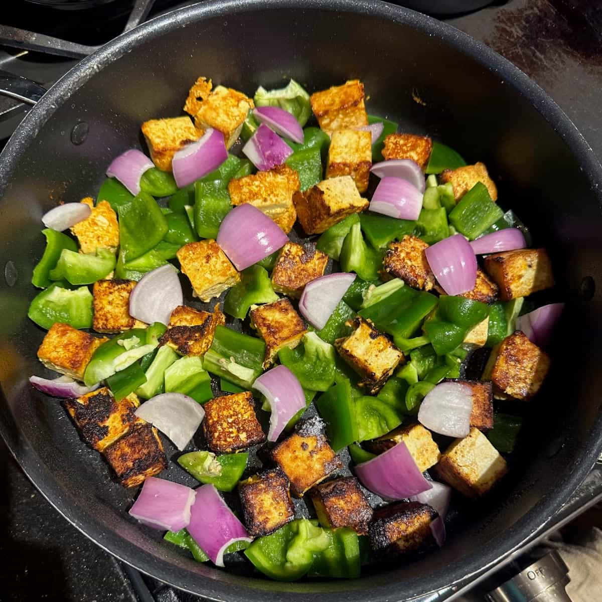 Bell peppers and tofu cubes in saute pan.