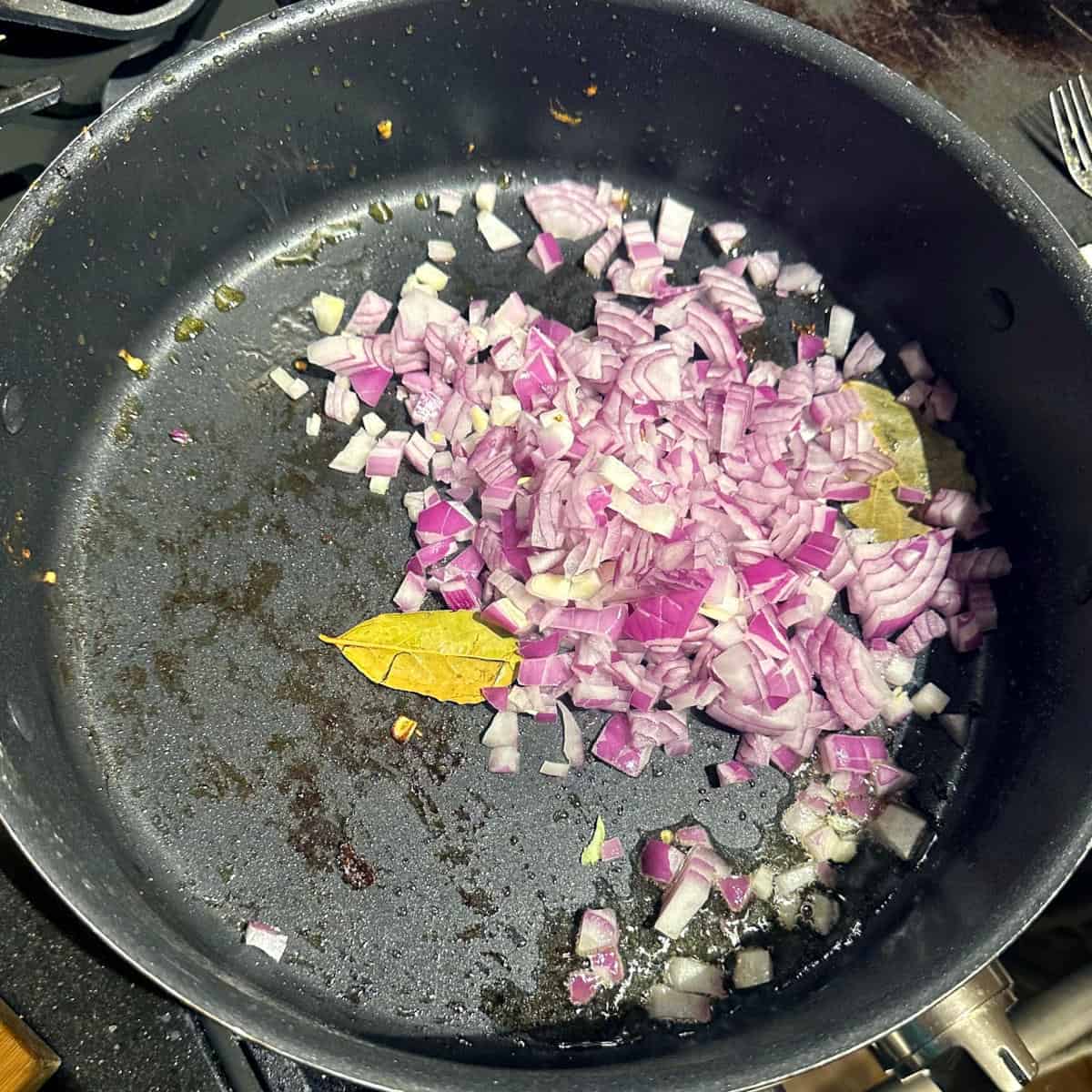 Onions and bay leaves in saute pan.