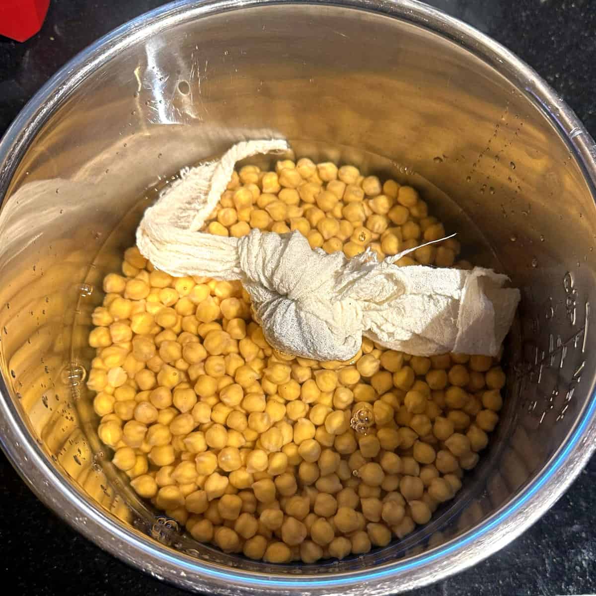 Chickpeas in Instant Pot liner with spice and tea leaves bundle.