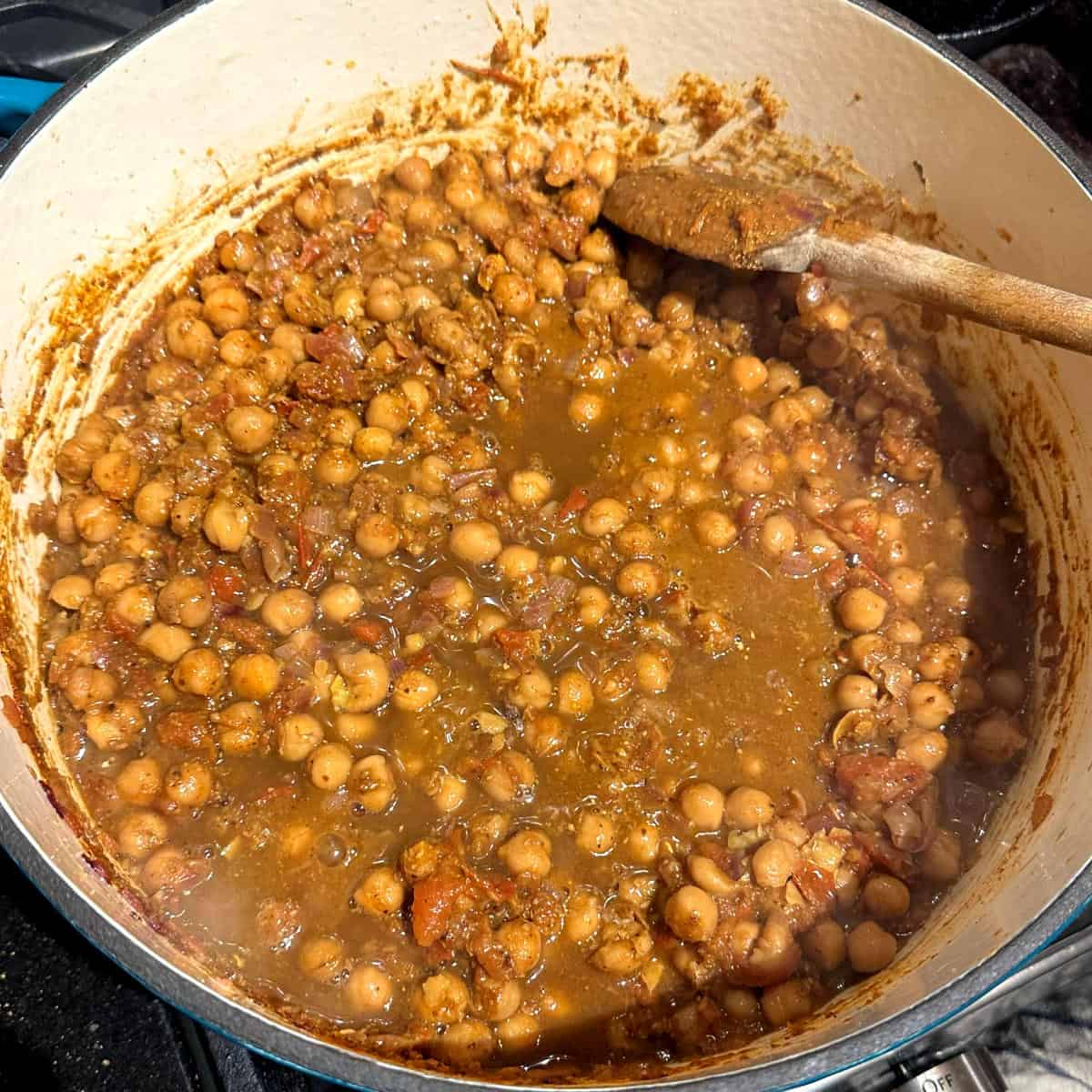 Chickpeas simmering with liquid in pot.