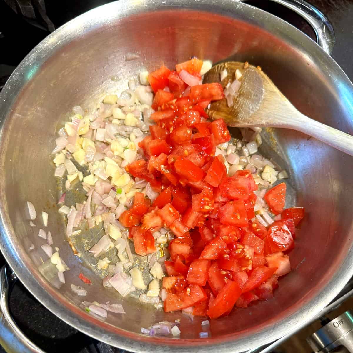 Tomatoes, onions and garlic in pan.