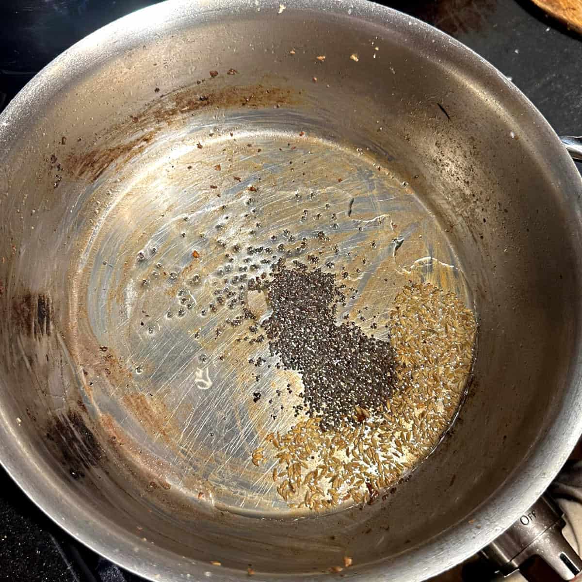 Mustard seeds and cumin seeds in oil.