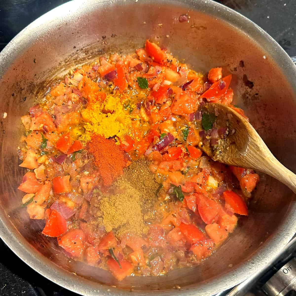 Turmeric, cayenne and garam masala and other spices added to pan.